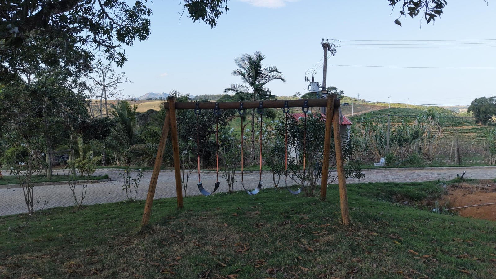 Miniatura: Área verde com árvores e construção rural ao fundo em Fundão